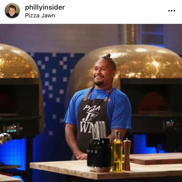 A smiling chef in a "Pizza Jawn" apron stands before two golden pizza ovens.
